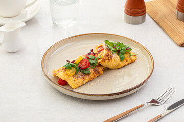 Portion of gourmet omelette with tomatoes, basil and parmesan