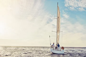 Foto op Plexiglas Couple sailing on yacht, adventure and travel with nature, luxury vacation on the ocean for summer holiday. Wealthy people out at sea, lifestyle with blue sky, romantic getaway with seascape mockup © Grady R/peopleimages.com