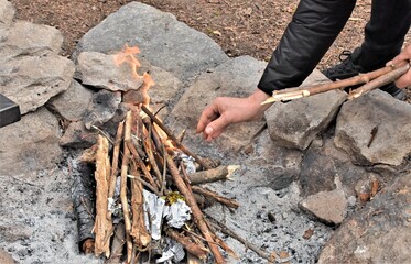 man lighting a fire outdoors