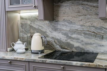 Authentic closeup view of custom designed kitchen, with marble looking quartz countertop and...