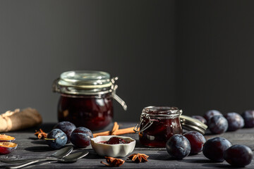 plum prune fruit jam with spices on a dark wooden background, the concept of preservation at home