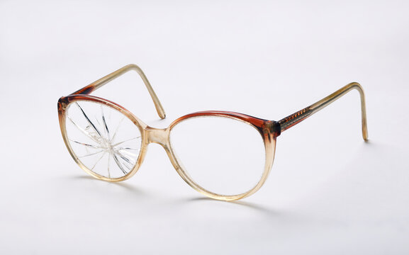 Old broken glasses on a white background.