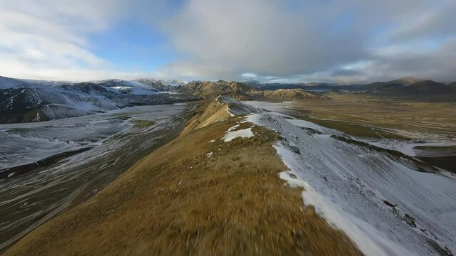 Flying parallel to a mountain ridge, sunny winter day in Iceland - FPV drone shot
