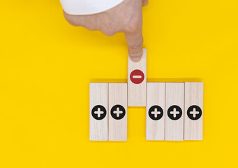 Plus and minus icons on wooden cubes. Separate the negative from positive, removing the weaknesses or negativity, positive thinking, negative feedback or subtraction