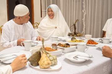 Fototapeta na wymiar Family interaction when eating food at dining room during the Eid Mubarak ramadan celebration