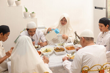 Fototapeta na wymiar Muslim woman pouring water at the dining room during the Eid Mubarak ramadan celebration. 