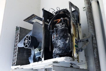 Fire burned damage on compressor air conditioner in office building from short circuit. 