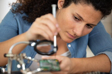 Obraz na płótnie Canvas a woman engineer repairing motherboard