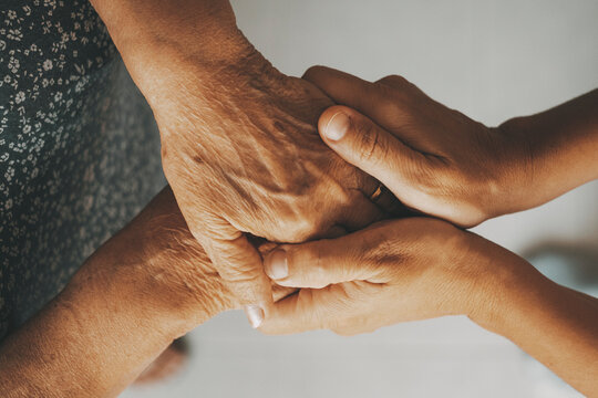 Caring elderly grandma wife holding hand supporting senior grandpa husband give empathy care love, old married grandparents couple together two man and woman hope understanding concept, close up view