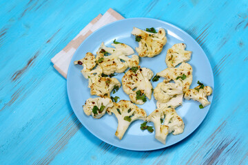 Roasted cauliflower slices, parsley. Healthy eating, plant-based diet. Vegetarian organic food.
