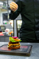 chef hand cooking cheeseburger on restaurant kitchen