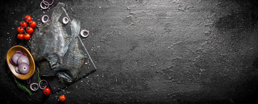 Raw flounder with cherry tomatoes and chopped onion in bowl.