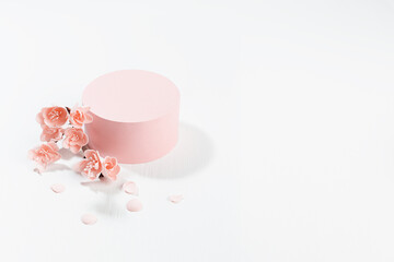 Valentine's Day stage mockup with pink cylinder podium and twig of gentle sakura flowers, petals on light white wood background in sunlight for presentation cosmetic products, goods, branding, design.