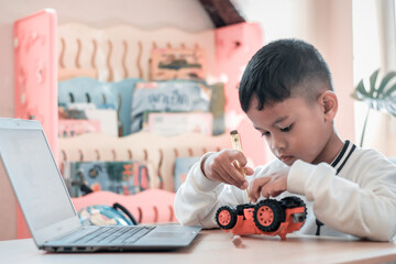 Asian boy students learn at home in coding robot cars and electronic board cables in STEM, STEAM, mathematics engineering science technology computer code in robotics for kids concept.