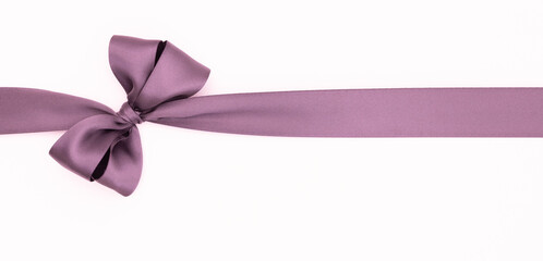 Nœud de ruban de satin pour paquet cadeau de couleur mauve, isolé sur du fond blanc....