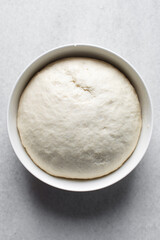 Bread dough that has doubled in size, dough that has risen, proofed dough in a white bowl	