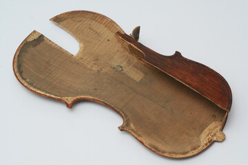 Broken antique violin for restoration with a lot of damage on white background
