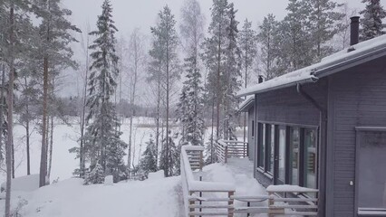 Winter scene of Ski resort cabin covered in Snow at Nordic landscape, Aerial Pullback