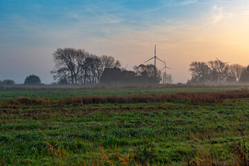 Ground fog in the dusk of the typical flat landscapes of East Frisia in the tourist resort Norddeich directly at the north sea behind the dyke