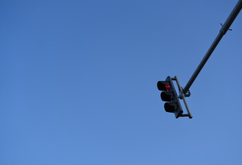 Car traffic red light sign on a pole against blue sky background. Infrastructure industry photo..