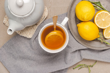 Cup of tea and lemon. A cup of tea with lemon, mint, ginger and honey on on grey table. Flat lay. Top view