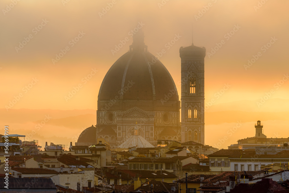 Wall mural the florence cathedral in a golden misty sunrise early morning.