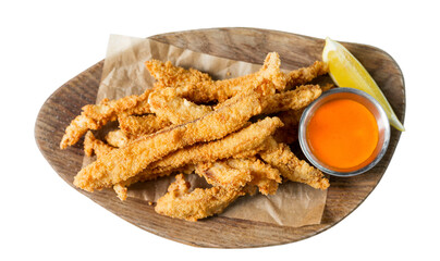 Fried breaded small fish with lemon and sauce served on a wooden board. Traditional tasty appetizer. Isolated on white background. Top view.