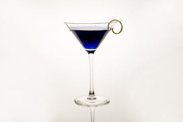Royal Blue Martini served with a lemon twist isolated on a white background