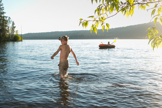 Two Boys swimming and playing on an inflatable raft in Duck Bay on Payette Lake in McCall, Idaho