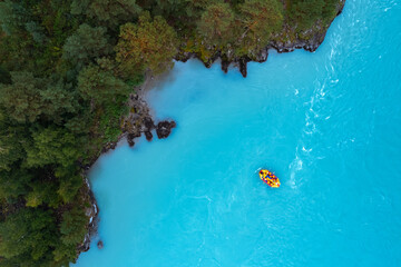 Blue water extreme travel rafting on alpine river, aerial top view