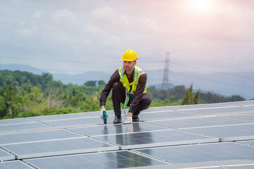 Engineer using dril installing solar cell on roof factory,Environment friendly,Alternative energy to conserve the world's energy.