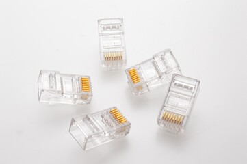 Several rg 45 connectors for internet cables lie on a light background. Close-up