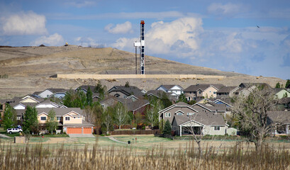 Houses in front of oil and gas drilling operation, Erie, Colorado, USA
