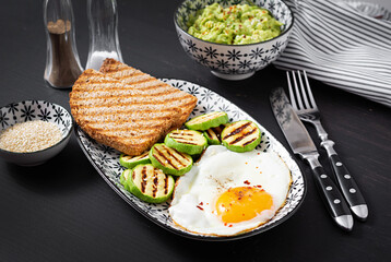 Breakfast. Toast with avocado guacamole, grilled zucchini and fried egg.  Brunch.