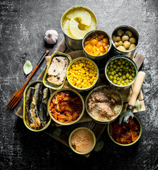 Various canned food in metal cans on tray.