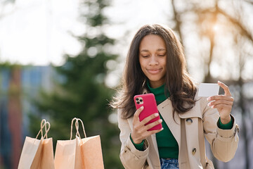 Woman holding a credit card and using cell phone for online shopping  