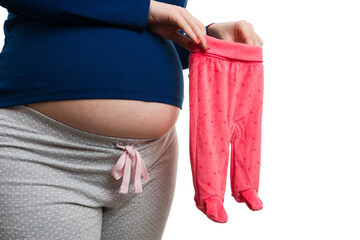 Close-up of pregnant woman holding pink baby pants with socks