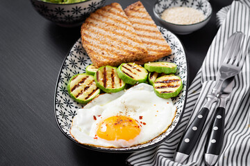 Breakfast. Toast with avocado guacamole, grilled zucchini and fried egg.  Brunch.