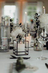 Blumen und Kerzen auf gedecktem Hochzeitstisch