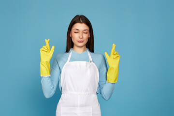 girl in yellow rubber gloves with finger crossed gesture