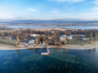 Luftaufnahme von der Halbinsel Mettnau mit dem Schiffanleger, Strandcafe und Kur- und Rehazentrum, am Horizont die Ortschaft Markelfingen