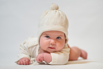 Portrait of an infant wearing light clothes and a knitted hat