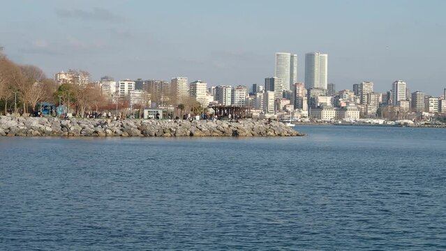 People walking and resting along embankment of Kadikoy district and Moda street in Istanbul, Turkey
