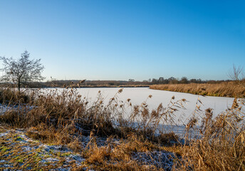Winter landscape with frozen canal in Drenthe, Netherlands
