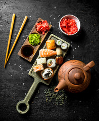 Sushi rolls with shrimp, salmon and vegetables on a cutting Board with chopsticks.