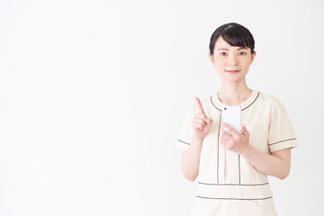 スマートフォンを操作するエステ・美容クリニックの女性