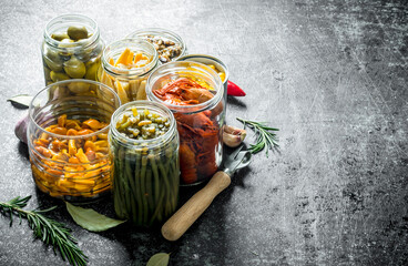 Pickled food in jars of rosemary and garlic.
