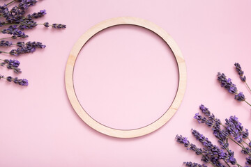 Lavender flowers on colored background with round frame top view. Copy space.
