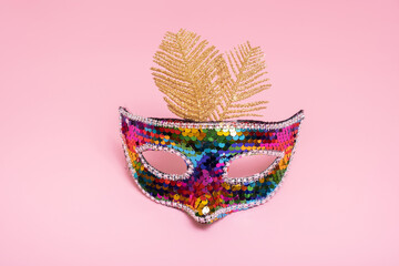 Festive face mask for carnival or masquerade celebration on colored background