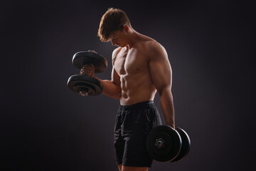 Young handsome sportsman bodybuilder weightlifter with an ideal body, after coaching poses in front...